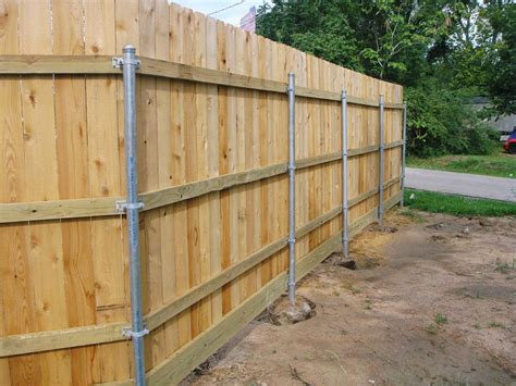 boxing in metal fence posts|Wrapping steel posts with wood when building wood fence.